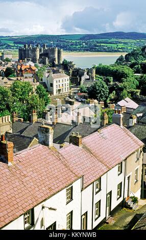 Medieval Conwy Castle, built by King Edward I, Snowdonia, in the Gwynedd region of north Wales. Over rooftops from the town wall Stock Photo