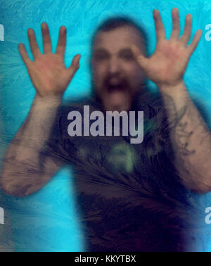 Man trapped behind window with help sign Stock Photo - Alamy