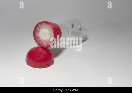 glass empty pepper mill with red top, laying on side Stock Photo