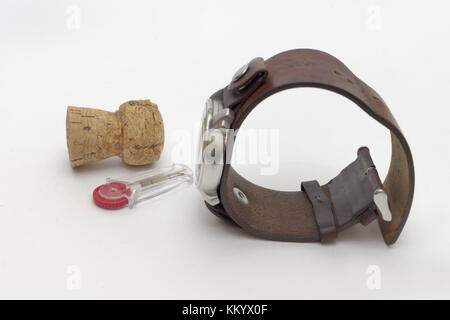 set of men's watch on leather strap, champagne cork and flint holder with plastic red wheel Stock Photo