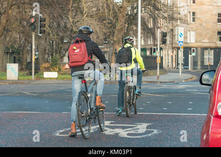 cyclists using bike box with advanced stop line on road at traffic lights in Edinburgh city centre, Scotland, UK Stock Photo