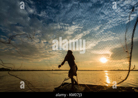 Asia fisherman using net fishing on wooden boat casting net sunset or  sunrise in the river - Silhouette fisherman stand on boat life person at  country Stock Photo - Alamy