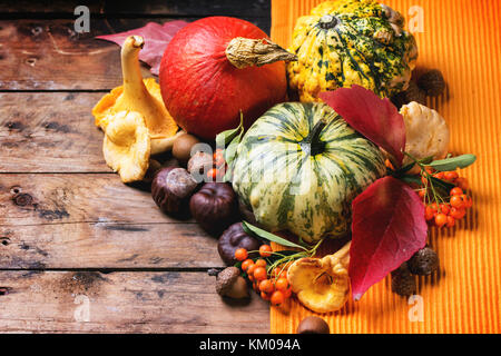 Pumpkins, nuts, berries and mushrooms chanterelle over old wooden table. See series Stock Photo