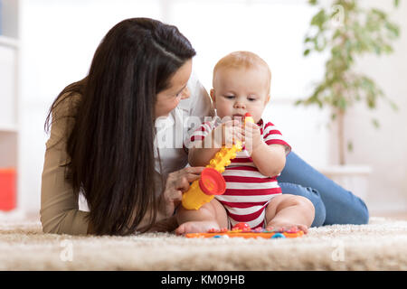 Happy mother playing with baby at home Stock Photo