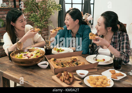 group of people enjoys pizza together at home. Stock Photo