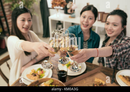 Friends hands toasting champagne glass and having fun cheering - Young people enjoying harvest time together at home party - Youth and friendship conc Stock Photo