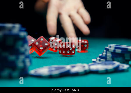 Image of man throwing dice on table with chips in casino Stock Photo