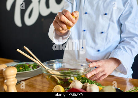 Sprinkling Salad with Lemon Juice Stock Photo