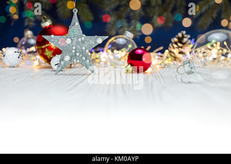 silver star and glass balls on white wooden background with blurred christmas lights Stock Photo