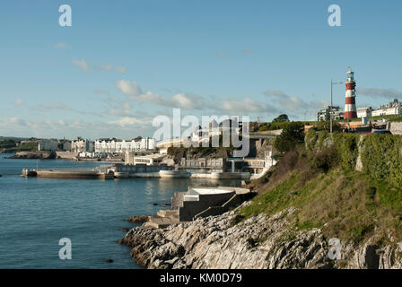 The foreshore of Plymouth in the sun with The Hoe, Tinside Lido, Smeatons Tower lighthouse, with cafes/  hotels/ apartments in the background. Stock Photo