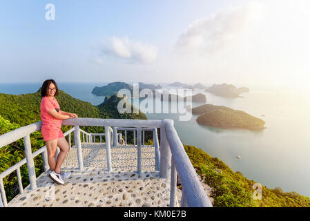 Woman tourist on the balcony is peak view point of Ko Wua Ta Lap island and beautiful nature landscape during sunrise over the sea in Mu Ko Ang Thong  Stock Photo