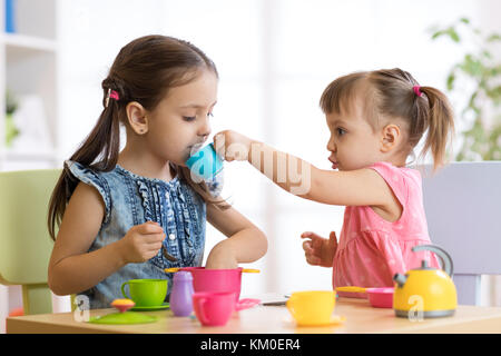 Kids playing with plastic tableware Stock Photo