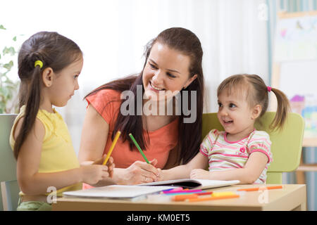 Teacher mom working with creative kids Stock Photo