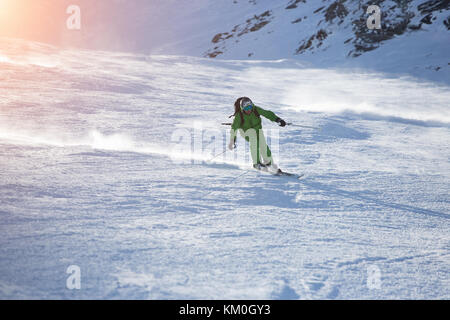 Attractive Male Skier Rides down the Slope on A Sunny Day