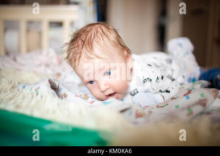 A newborn lies on his stomach and learn to keep your head Stock Photo