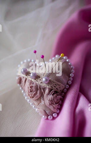 Pink pincushion heart on a light background. Stock Photo