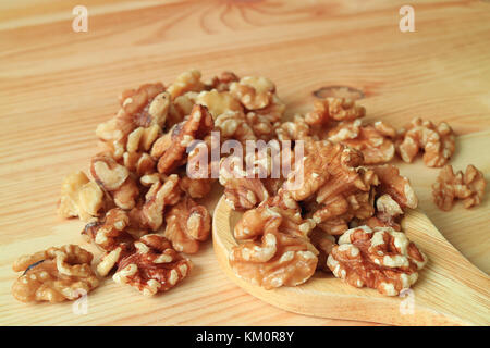 Close-up of Walnuts Scattered from Wooden Spoon on the Wooden Table, Selective Focus and Blurred Background Stock Photo