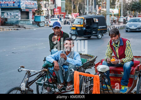Local cycle rickshaw drivers resting in the street on their rickshaws in Amritsar, a city in north-western India in the Majha region of Punjab Stock Photo
