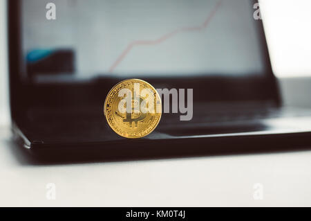 Golden bitcoin on black keyboard with stock graph. business concept. Digital currency physical golden bitcoin coins on black computer keyboard. Electr Stock Photo