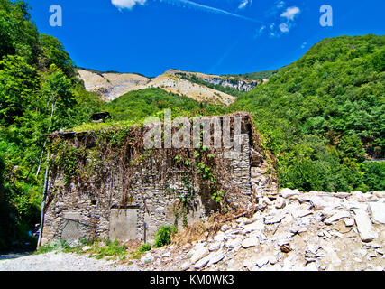 stone building collapsed due to the earthquake and flooded by plants under the blue sky Stock Photo