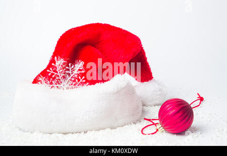 Big Santa hat and red Christmas decorations on white background Stock Photo