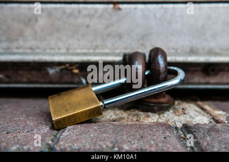 Padlock securing the shutter of a shop. Stock Photo