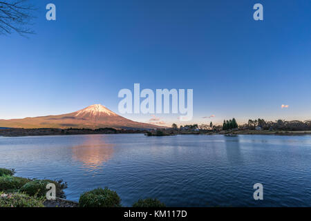 Beautiful clear sky Sunset at Tanuki Lake Tanukiko. Fuji mountain reflections, first snow in autumn season. Located near Tokai Nature Trail, Shizuoka Stock Photo