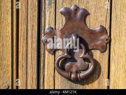 close up of vintage metal lock plate with door knocker on weathered wooden door Stock Photo