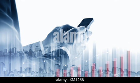 Double exposure Businessman using mobile smart phone with raising graph Stock Photo