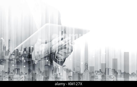 Double exposure Businessman working on digital tablet with modern buildings. Business growth and investment Stock Photo