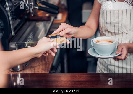 customer pay coffee drink with credit card to barista,Close up hand paid for to go coffee cup at counter bar in cafe,Food and drink business,billing p Stock Photo