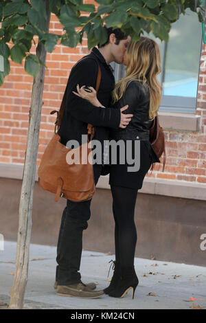 NEW YORK - OCTOBER 06: Actress Hilary Duff and actor Penn Badgley share a kiss while filming on location for 'Gossip Girl' on the streets of Manhattan On October 6, 2009 in New York City.  People:  Hilary Duff, Penn Badgley Stock Photo