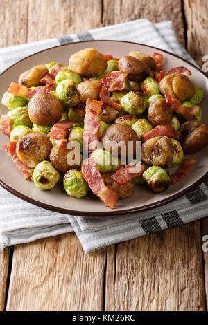 Homemade salad of roasted chestnuts, brussels sprouts and bacon closeup on a plate. vertical Stock Photo