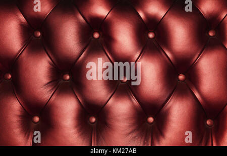 Burgundy dark red capitone genuine leather background, retro Chesterfield style soft tufted furniture upholstery with deep diamond pattern and buttons Stock Photo
