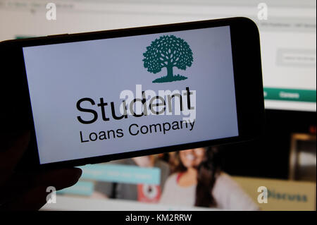 The Student Loans Company logo on a phone with the website on a computer screen Stock Photo