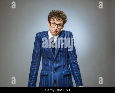 Portrait of confised man giving I dont know gesture on gray background Stock Photo