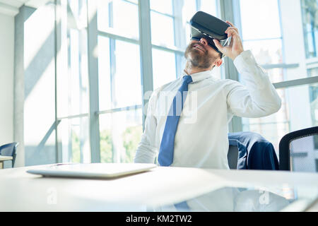 Mature Businessman Using VR Glasses in Office Stock Photo