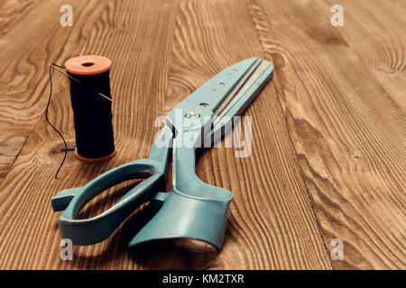 Vintage sewing table with scissors, threads, tailored details Stock Photo