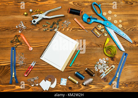 Blank notebook and Sewing tools on wooden textured background, copy-space. Stock Photo
