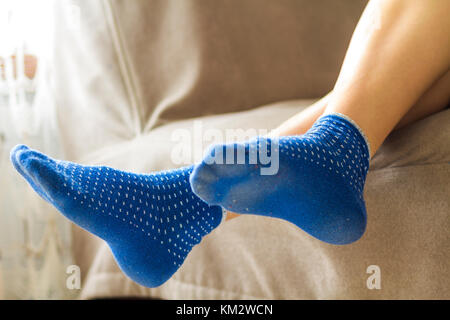Woman feet in blue socks.Relaxing and comfort holiday concept. Stock Photo