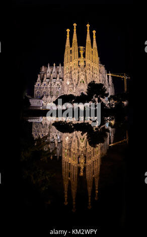 BARCELONA, SPAIN - FEBRUARY 4, 2015: La Sagrada Familia - cathedral designed by Antonio Gaudi, Full moon night view from oldest facade with cranes Stock Photo