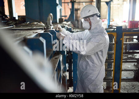 Worker in Hazmat Suits at Modern Factory Stock Photo