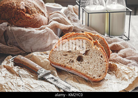 A beautiful loaf of sourdough bread from white wheat on a plate on a linen edge. Homemade pastries. Stock Photo