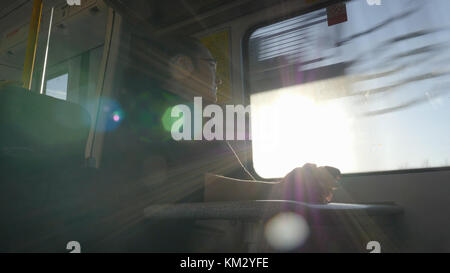 Low anglw view Woman sitting in British train and looking through window. Stock Photo