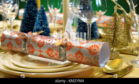 Festive Christmas lunch table in modern gold, copper, and white theme against a green background. Stock Photo
