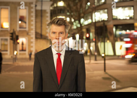 Portrait of a smart middle aged caucasian businessman standing still at rush hour Stock Photo