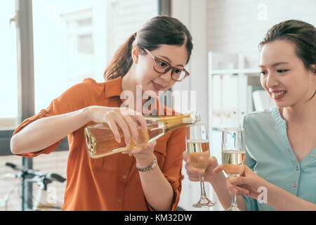 Group of business asia people holding flutes with champagne and smiling while standing enjoy drink champagne indoors Stock Photo