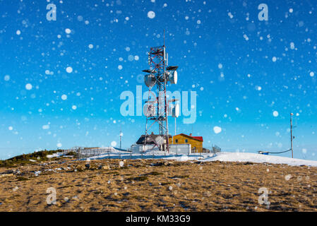 Meteorological weather station on the top of the mountain during winter. Radar tower. Heavy snowfall Stock Photo