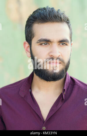 Portrait of a young Pensive Middle Eastern man looking away outdoors Stock Photo