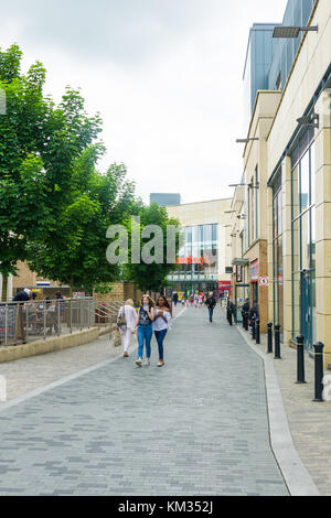 Shoppers walking around Pioneer Square urban regeneration with Sainsburys supermarket in background, Bicester town, England, United Kingdom Stock Photo